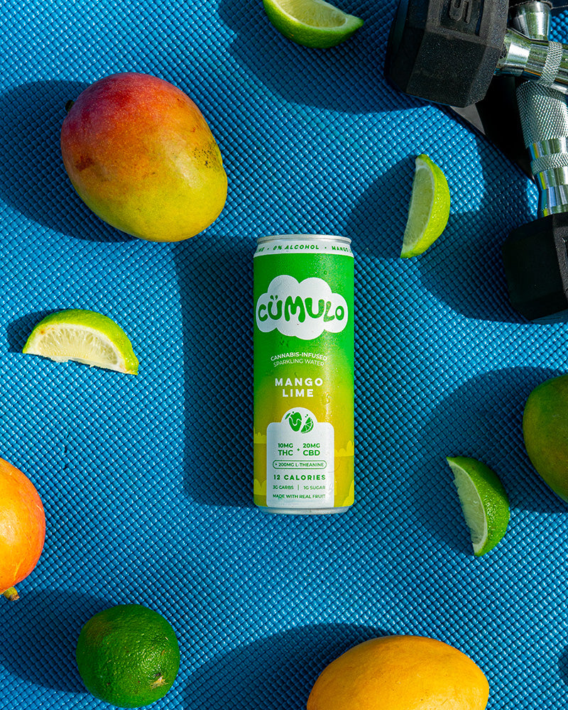 Cümulo Mango Lime can with mangoes and limes on a blue yoga mat