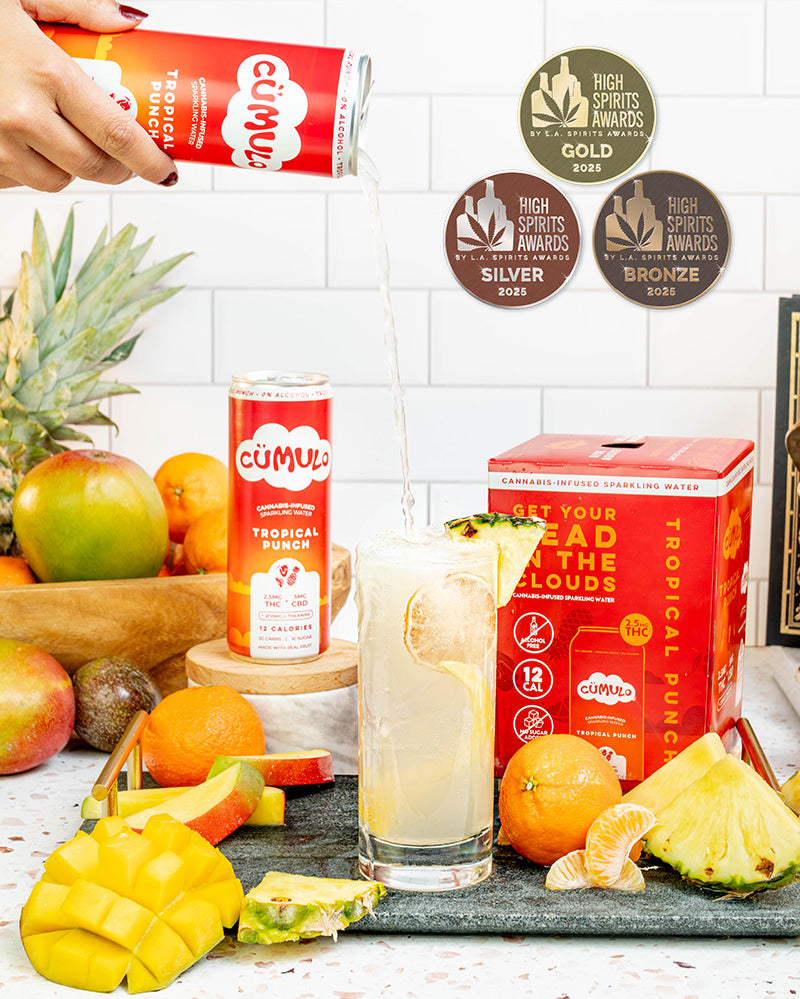 Cümulo Tropical Punch drink with award medals on a white tiled background